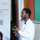 Mastercard Foundation Scholar on stage presenting